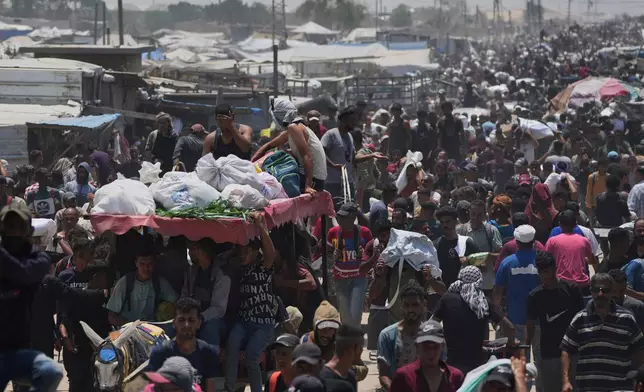Palestinians carry bags containing food and humanitarian aid packages delivered by the Gaza Humanitarian Foundation, a U.S.-backed organization, in Rafah, southern Gaza Strip, Tuesday, June 10, 2025. (AP Photo/Abdel Kareem Hana)