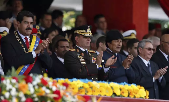 FILE - Venezuela's President Nicolas Maduro, from left, Operational Strategic Commander Gen. Vladimir Padrino Lopez, Bolivia's President Evo Morales and Cuba's President Raul Castro applaud during a military parade commemorating the one year anniversary of the death of Venezuela's former President Hugo Chavez in Caracas, Venezuela, March 5, 2014. (AP Photo/Fernando Llano, File)