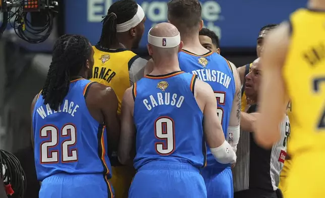 Oklahoma City Thunder and Indiana Pacers players are separated by the referees during the first half of Game 4 of the NBA Finals basketball series, Friday, June 13, 2025, in Indianapolis. (AP Photo/Michael Conroy)