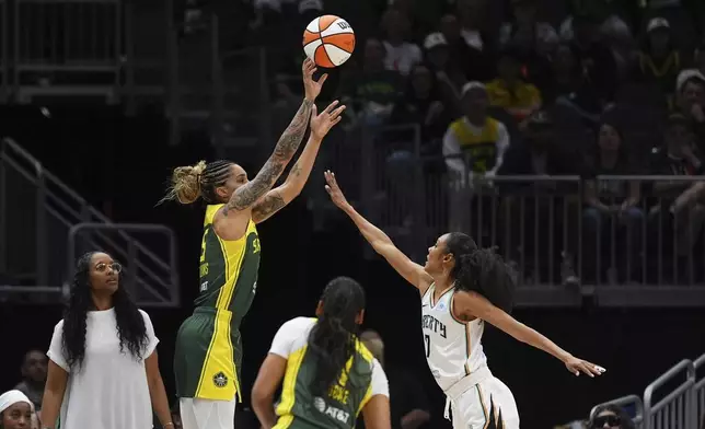 Seattle Storm forward Gabby Williams, left, makes a three-point basket against New York Liberty guard Rebekah Gardner, right, during the first half of a WNBA basketball game Sunday, June 22, 2025, in Seattle. (AP Photo/Lindsey Wasson)
