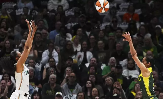 Seattle Storm guard Skylar Diggins, right, makes a three-point basket against New York Liberty guard Rebekah Gardner, left, during the first half of a WNBA basketball game Sunday, June 22, 2025, in Seattle. (AP Photo/Lindsey Wasson)