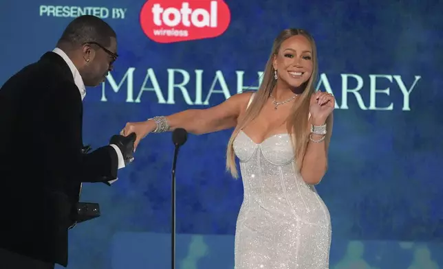 Busta Rhymes, left, presents the ultimate icon award to Mariah Carey during the BET Awards on Monday, June 9, 2025, at the Peacock Theater in Los Angeles. (AP Photo/Chris Pizzello)