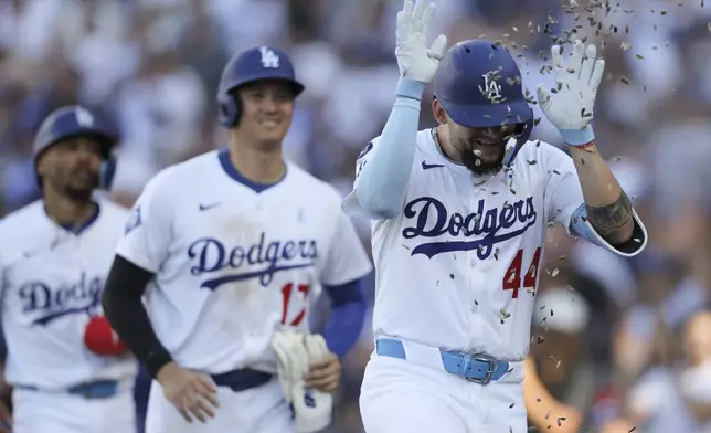 Los Angeles Dodgers' Andy Pages (44) celebrates with sunflower seeds after hitting a home run as designated hitter Shohei Ohtani (17) reacts during the fifth inning of a baseball game against the San Francisco Giants in Los Angeles, Sunday, June 15, 2025. (AP Photo/Jessie Alcheh)