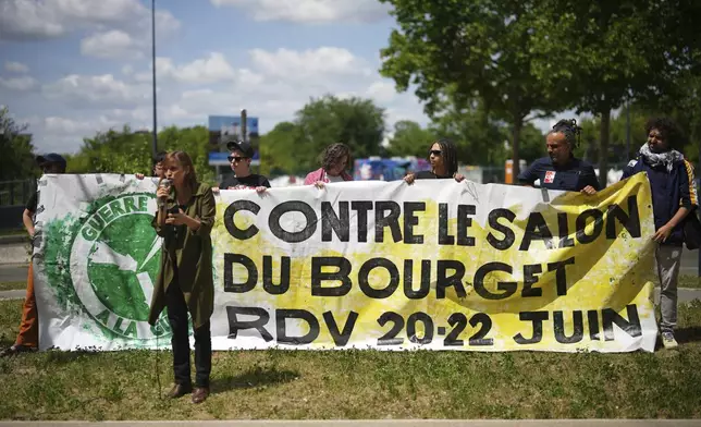 Activists stage a protest outside the Paris Airshow, Monday, June 16, 2025 in Le Bourget, outside Paris. (AP Photo/Thibault Camus)