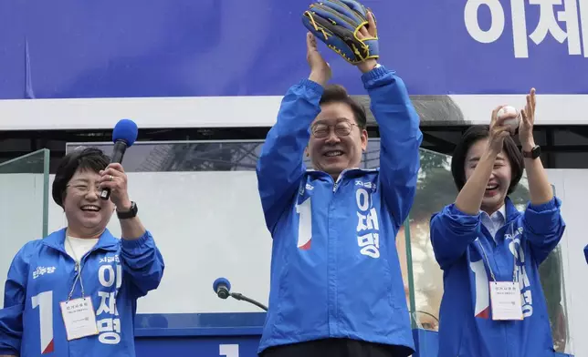South Korea's Democratic Party's presidential candidate Lee Jae-myung, center, reacts after hurling a baseball ball during a presidential election campaign at Jamsil Sports Complex in Seoul, South Korea, Thursday, May 29, 2025. (AP Photo/Ahn Young-joon)