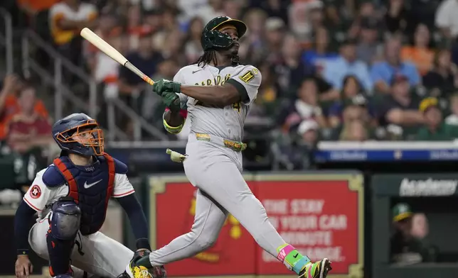 Athletics' Lawrence Butler, right, hits a three-run home run as Houston Astros catcher Yainer Diaz watches during the ninth inning of a baseball game Saturday, July 26, 2025, in Houston. (AP Photo/David J. Phillip)