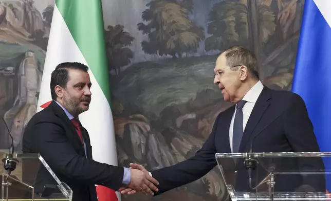 Russian Foreign Minister Sergey Lavrov, right, and Syrian Foreign Minister Asaad Hassan al-Shibani, left, shake hands after a joint news conference following their meeting in Moscow, Russia, Thursday, July 31, 2025. (Shamil Zhumatov/Pool Photo via AP)
