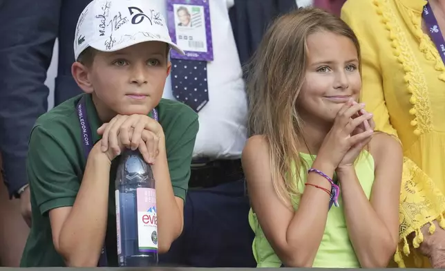 Stefan and Tara, the children of Serbia's Novak Djokovic smile after their father beat Italy's Flavio Cobolli in a quarterfinal men's singles match at the Wimbledon Tennis Championships in London, Wednesday, July 9, 2025. (AP Photo/Kin Cheung)