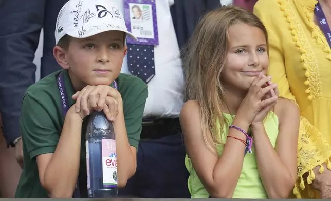 Stefan and Tara, the children of Serbia's Novak Djokovic smiles after their father beat Italy's Flavio Cobolli in a quarterfinal men's singles match at the Wimbledon Tennis Championships in London, Wednesday, July 9, 2025. (AP Photo/Kin Cheung)