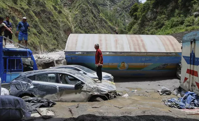 Damaged vehicles are seen after severe monsoon rains flooded the Bhotekoshi River and swept away a key bridge connecting the country with China at Rasuwagadi,120 kilometers (75 miles) north of the capital, Kathmandu, Nepal, Wednesday, July, 9, 2025. (AP Photo/Sujan Gurung)