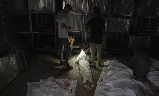 Palestinians mourn relatives killed in an Israeli army bombardment of Gaza at the morgue of Shifa Hospital in Gaza City Tuesday, July 22, 2025. (AP Photo/Jehad Alshrafi)