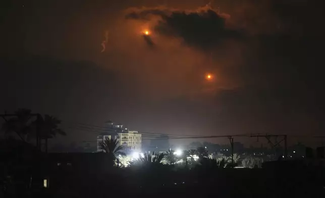 Illumination flares launched by the Israeli army are seen over Deir al-Balah in central Gaza Strip Monday, July 21, 2025. (AP Photo/Abdel Kareem Hana)