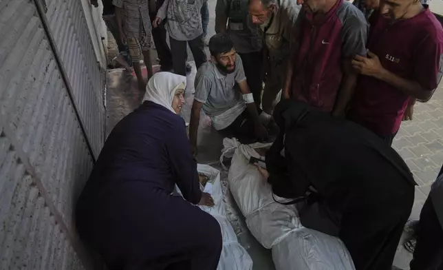 Mourners attend the funeral of their relatives killed in an Israeli bombardment, in Deir al-Balah, central Gaza Strip, Monday, July 21, 2025. (AP Photo/Abdel Kareem Hana)