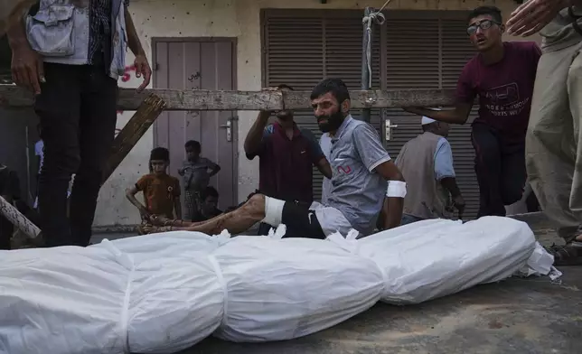 Mourners attend the funeral of their relatives killed in an Israeli bombardment, in Deir al-Balah, central Gaza Strip, Monday, July 21, 2025. (AP Photo/Abdel Kareem Hana)