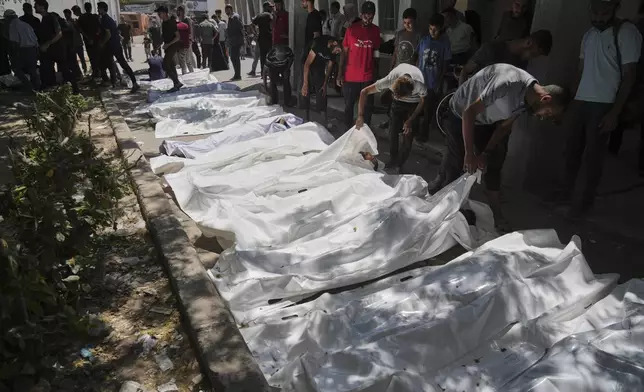 The bodies of Palestinians who were killed while attempting to access aid trucks entering northern Gaza through the Zikim crossing with Israel are brought to a clinic in Gaza City, Sunday, July 20, 2025. (AP Photo/Jehad Alshrafi)
