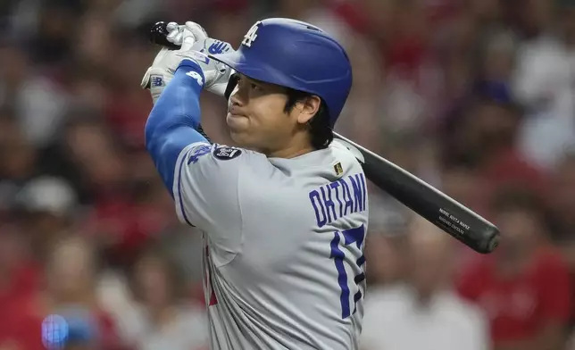 Los Angeles Dodgers' Shohei Ohtani watches his double to score Miguel Rojas and Mookie Betts during the fifth inning of a baseball game against the Cincinnati Reds, Monday, July 28, 2025, in Cincinnati. (AP Photo/Carolyn Kaster)