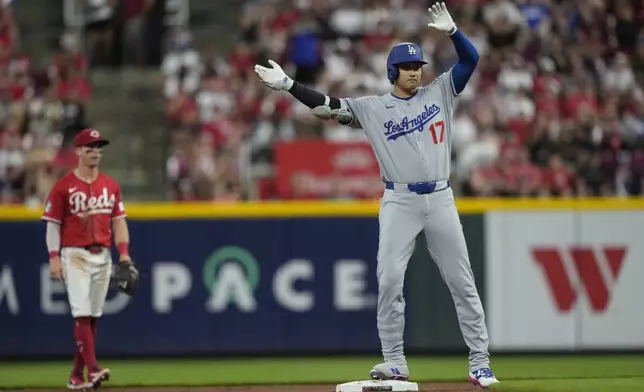 Los Angeles Dodgers' Shohei Ohtani celebrates on second base after hitting a double to score Miguel Rojas and Mookie Betts during the fifth inning of a baseball game against the Cincinnati Reds, Monday, July 28, 2025, in Cincinnati. (AP Photo/Carolyn Kaster)