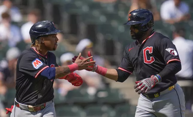 Cleveland Guardians' Carlos Santana, right, celebrates with José Ramírez, left, after hitting a two-run home run during the sixth inning of the first baseball game of a doubleheader against the Chicago White Sox, Friday, July 11, 2025, in Chicago. (AP Photo/Erin Hooley)