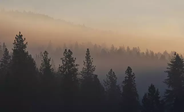 Smoke fills the air the day after a shooter ambushed and killed multiple firefighters responding to a wildfire at Canfield Mountain Monday, June 30, 2025, in Coeur D'Alene, Idaho. (AP Photo/Lindsey Wasson)