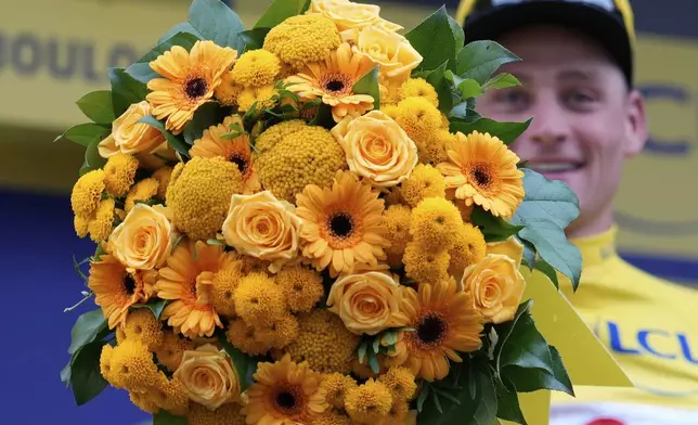 Netherlands' Mathieu van der Poel wearing the overall leader's yellow jersey celebrates on the podium after winning the second stage of the Tour de France cycling race over 209.1 kilometers (129.9 miles) with start in Lauwin-Planque and finish in Boulogne-sur-Mer, France, Sunday, July 6, 2025. (AP Photo/Mosa'ab Elshamy)
