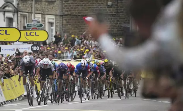 Netherlands' Mathieu van der Poel, left, sprints next to Slovenia's Tadej Pogacar to cross the finish line during the second stage of the Tour de France cycling race over 209.1 kilometers (129.9 miles) with start in Lauwin-Planque and finish in Boulogne-sur-Mer, France, Sunday, July 6, 2025. (AP Photo/Thibault Camus)