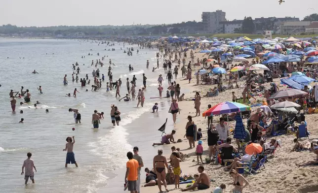 A crowd seeks relief from the heat Tuesday, July 29, 2025, at Old Orchard Beach, Maine. (AP Photo/Robert F. Bukaty)