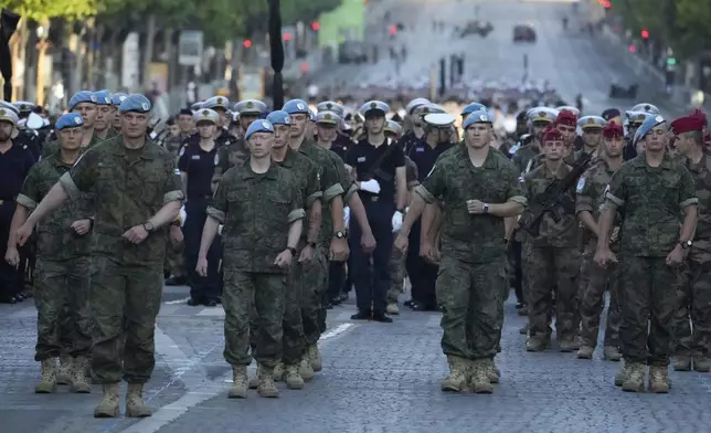 French and Finland's soldiers of the United Nations Interim Force in Lebanon (UNIFIL) stand during a rehearsal for the upcoming Bastille Day parade, Wednesday, July 9, 2025 on the Champs-Elysees avenue in Paris. (AP Photo/Michel Euler)