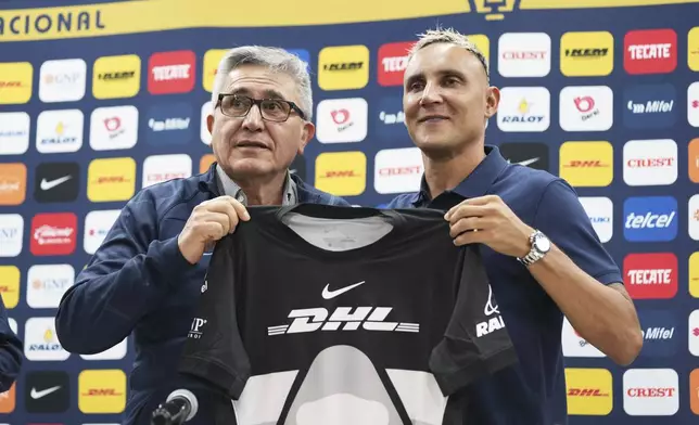 Costa Rican soccer goalkeeper Keylor Navas, right, poses with Pumas' President Luis Gonzalez Perez during his presentation in Mexico City, Thursday, July 24, 2025. (AP Photo/Eduardo Verdugo)