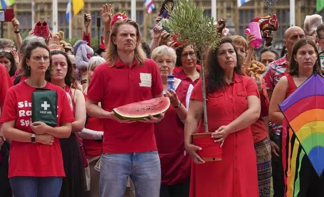 Members of the public wearing red demonstrate outside Parliament to protest the treatment of people in Gaza on the final day before summer recess at Parliament Square in London, Tuesday, July 22, 2025. (AP Photo/Frank Augstein)