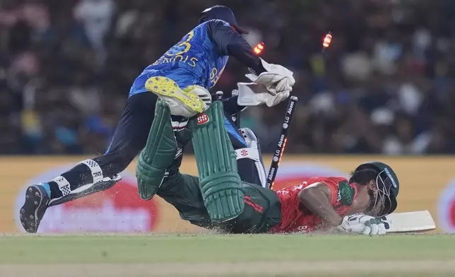 Bangladesh's Mohammad Saifuddin successfully dives into his crease as Sri Lanka's Kusal Mendis removes the bails during the second Twenty20 cricket match between Sri Lanka and Bangladesh in Dambulla, Sri Lanka, Sunday, July 13, 2025. (AP Photo/Eranga Jayawardena)