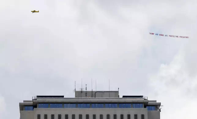An airplane towing a banner that reads "Trump and Bondi are protecting predators" is seen over the Florida Capitol, Friday, July 25, 2025, in Tallahassee, Fla., as Deputy Attorney General Todd Blanche meets with Ghislaine Maxwell, the imprisoned former girlfriend of financier and convicted sex offender Jeffrey Epstein in the nearby federal courthouse. (AP Photo/Colin Hackley)