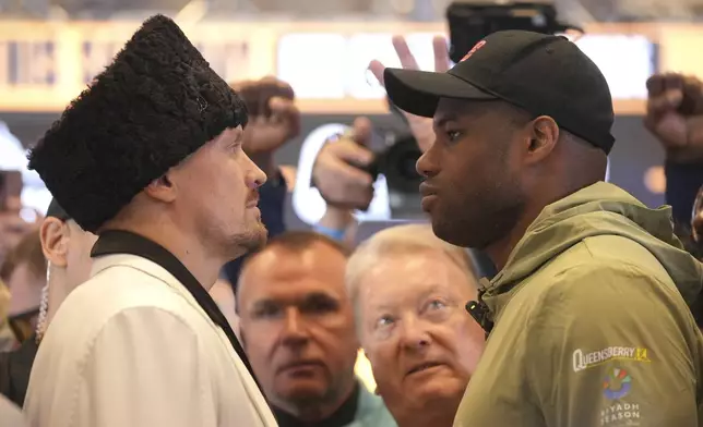 Ukraine's boxer Oleksandr Usyk, left, and Britain's Daniel Dubois attend a press conference in Wembley stadium in London, Thursday, July 17, 2025, ahead of their boxing fight on Saturday. (AP Photo/Kin Cheung)