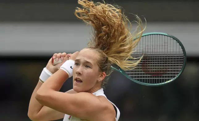 Mirra Andreeva of Russia returns to Emma Navarro of the U.S. during a fourth round women's singles match at the Wimbledon Tennis Championships in London, Monday, July 7, 2025. (AP Photo/Kin Cheung)