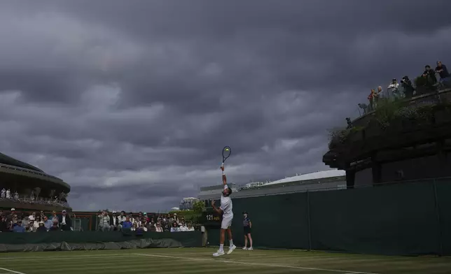Marin Cilic of Croatia serves to Jaume Munar of Spain during a third round men's singles match at the Wimbledon Tennis Championships in London, Saturday, July 5, 2025. (AP Photo/Joanna Chan)