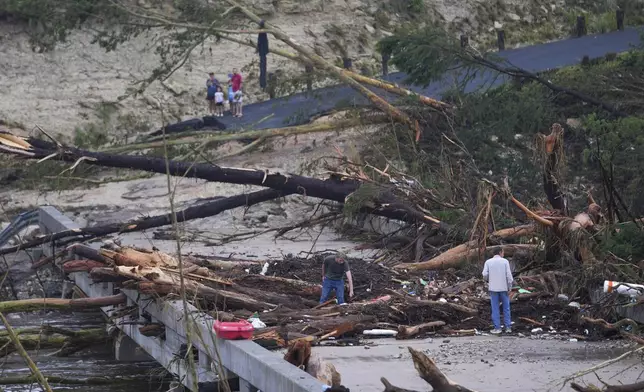 Debris rests on a bridge over the Guadalupe River after a flash flood swept through the area Saturday, July 5, 2025, in Ingram, Texas. (AP Photo/Julio Cortez)