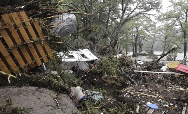 CORRECTS DAY - Damaged vehicles and debris are seen roped off near the banks of the Guadalupe River after flooding in Ingram, Texas, Friday, July 4, 2025. (Michel Fortier/The San Antonio Express-News via AP)