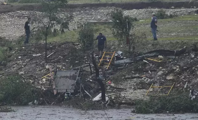 Men survey damage left by a raging Guadalupe River, Friday, July 4, 2025, in Kerrville, Texas. (AP Photo/Eric Gay)