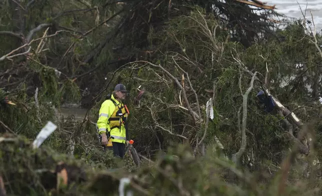A first responder searches an area along the Guadalupe River that was hit by flash flooding, Friday, July 4, 2025, in Kerrville, Texas. (AP Photo/Eric Gay)