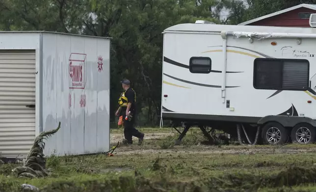 A first responder searches an area along the Guadalupe River that was hit by flash flooding, Friday, July 4, 2025, in Kerrville, Texas. (AP Photo/Eric Gay)