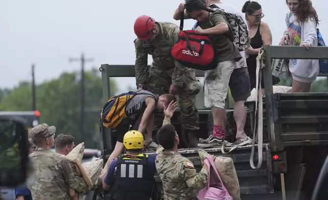 First responders deliver people to a reunification center after flash flooding in the area, Friday, July 4, 2025, in Ingram, Texas. (AP Photo/Eric Gay)