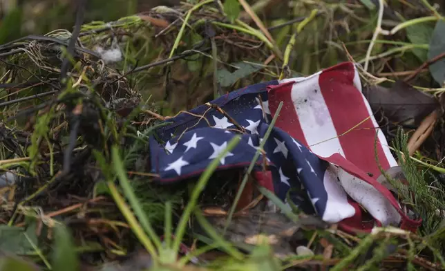A flag is tangled in debris along the Guyadalupe River after a flash flood struck the area, Friday, July 4, 2025, in Kerrville, Texas. (AP Photo/Eric Gay)