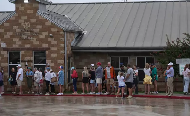 Families line up at a reunification center after flash flooding it the area, Friday, July 4, 2025, in Ingram, Texas. (AP Photo/Eric Gay)