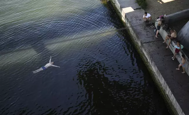 People cool off at the Bosphorus as they shelter against the sun under Halic bridge during a hot summer day, in Istanbul, Turkey, Friday, July 25, 2025. (AP Photo/Francisco Seco)
