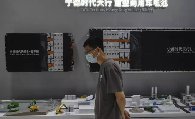 A visitor walks by the batteries' components manufactured by Contemporary Amperex Technology Co., Limited (CATL) showcasing at its booth during the 3rd China International Supply Chain Expo at the China International Exhibition Center, in Beijing on July 17, 2025. (AP Photo/Andy Wong)