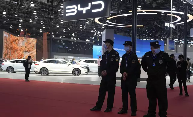 FILE - Security personnel on duty stand near the BYD booth during the Shanghai auto show on April 23, 2025. (AP Photo/Ng Han Guan, File)
