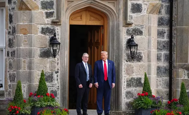 U.S. President Donald Trump, right, and British Prime Minister Keir Starmer walk at Trump International Golf Links in Aberdeenshire, Scotland, Monday, July 28, 2025. (Jane Barlow/Pool Photo via AP)