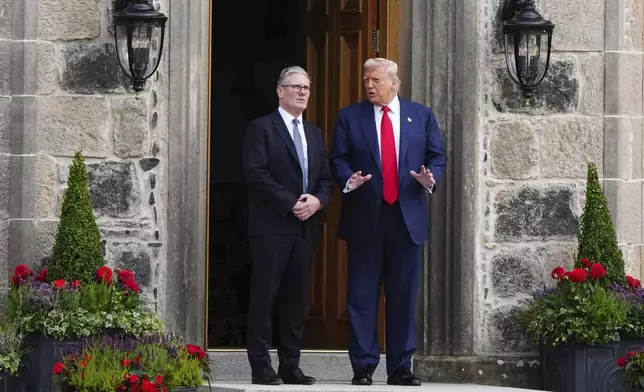 U.S. President Donald Trump, right, and British Prime Minister Keir Starmer walk at Trump International Golf Links in Aberdeenshire, Scotland, Monday, July 28, 2025. (Jane Barlow/Pool Photo via AP)