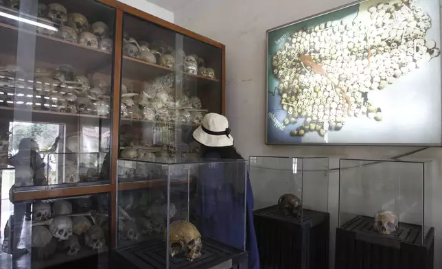 FILE - Tourists look at portraits of genocide victims in Khmer Rouge regime at the Tuol Sleng Genocide Museum, formerly the most notorious Khmer Rouge prison, in Phnom Penh, Cambodia, on July 10, 2014. (AP Photo/Heng Sinith, File)