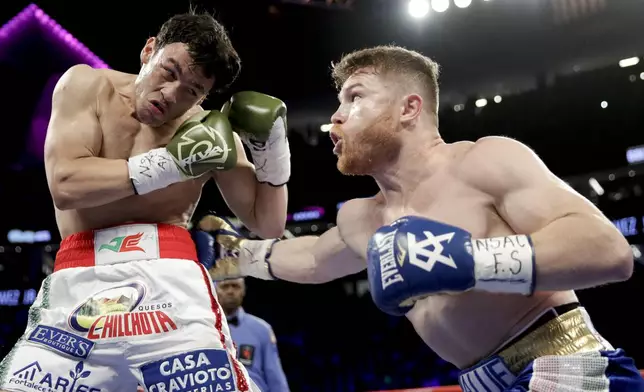FILE - Canelo Alvarez, right, of Mexico, hits Julio Cesar Chavez Jr., of Mexico, during their catch weight boxing match, in Las Vegas, May 6, 2017. (AP Photo/John Locher, File)