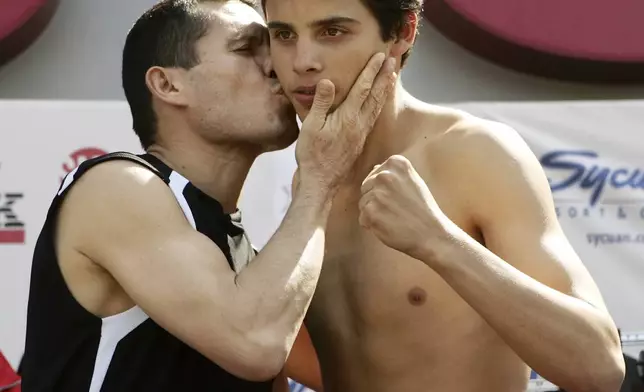 FILE - Julio Cesar Chavez, left, of Mexico kisses his son, Julio Jr., during a weigh-in at the Staples Center in Los Angeles, May 27, 2005. (AP Photo/Kevork Djansezian, File)